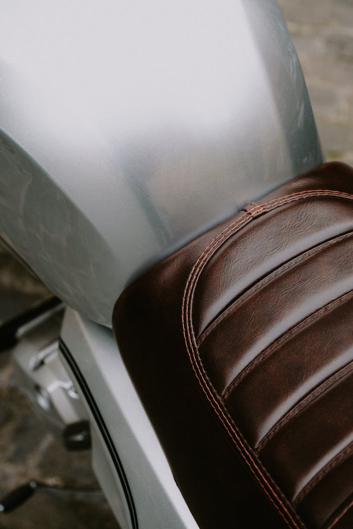 Detailed view of a vintage leather motorcycle seat, emphasizing its retro look and craftsmanship.