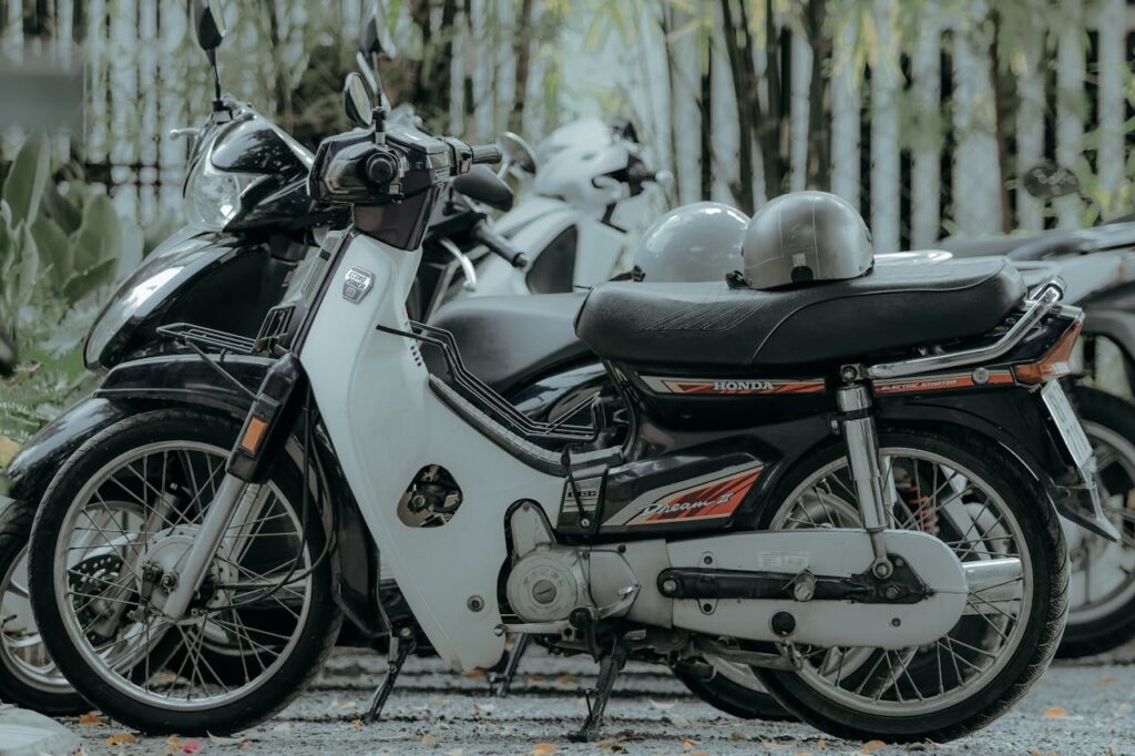 The Art of Drawing Readers In: Your attractive post title goes here A collection of vintage motorbikes parked outdoors under lush greenery.